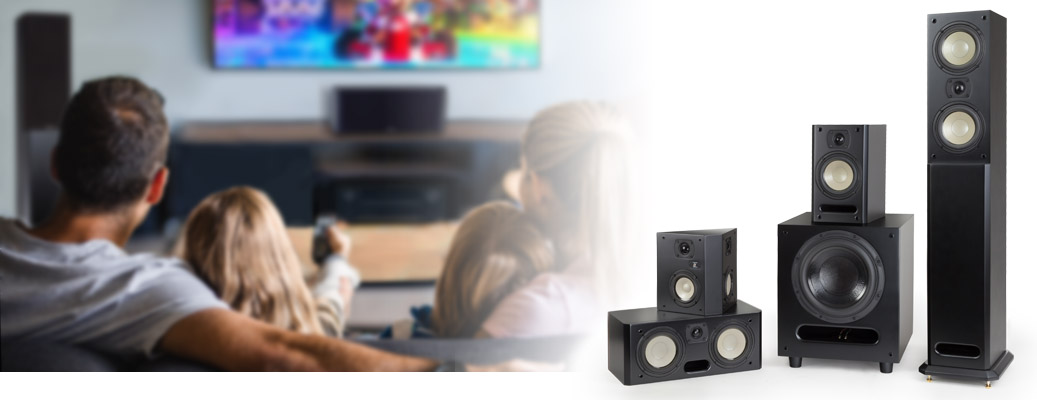 Man and woman watching tv. A family of Level Two Cabinet Speakers for home theater or high quality audio.